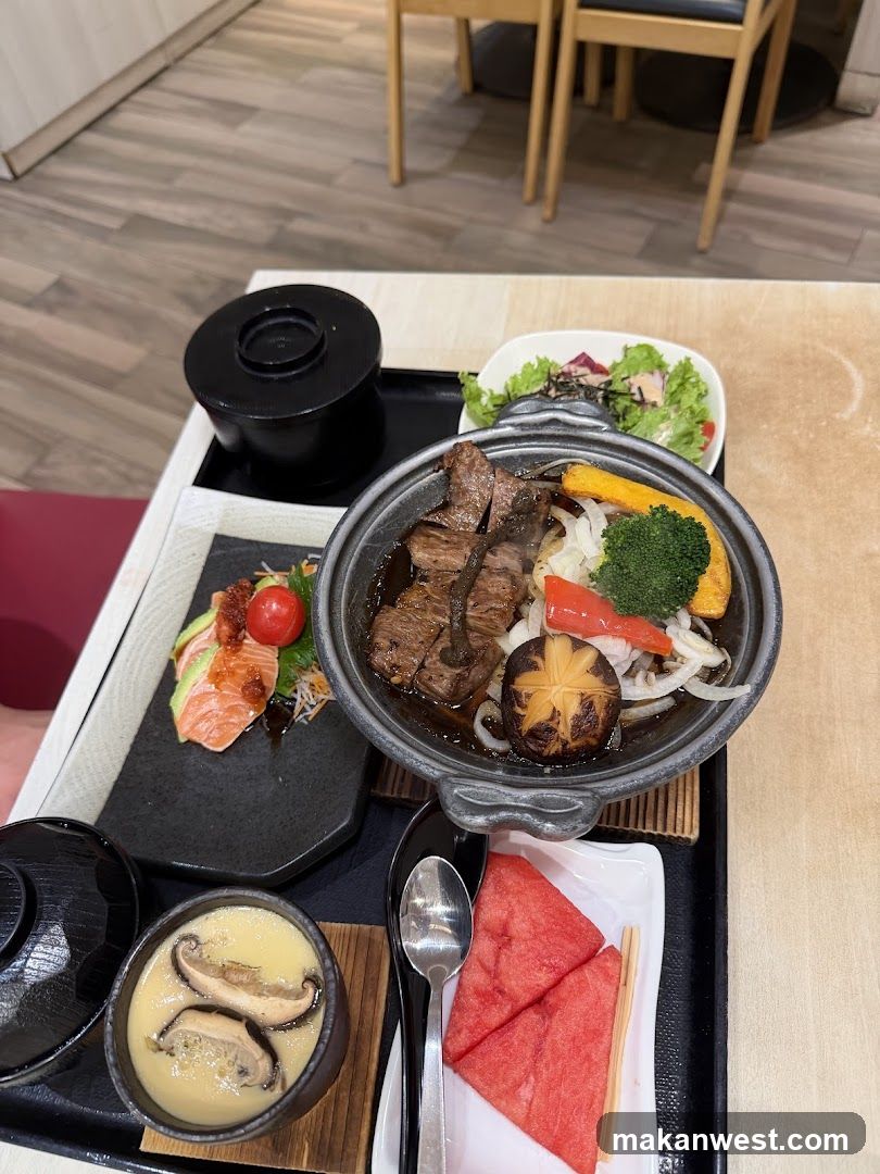 Japanese-style meal set with steak rice bowl, salad, and fruit