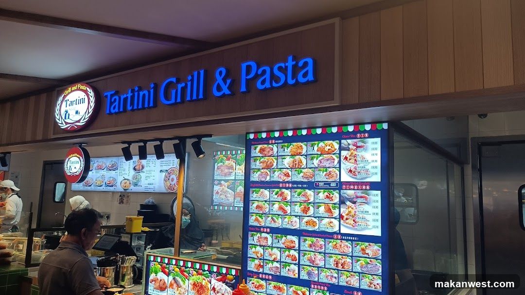 A storefront with a wooden facade and blue neon signage reading 'Tartini Grill & Pasta'. A circular logo is visible to the left of the sign. Inside, staff are preparing food behind glass counters. Large illuminated menu boards display various dishes with images and prices.