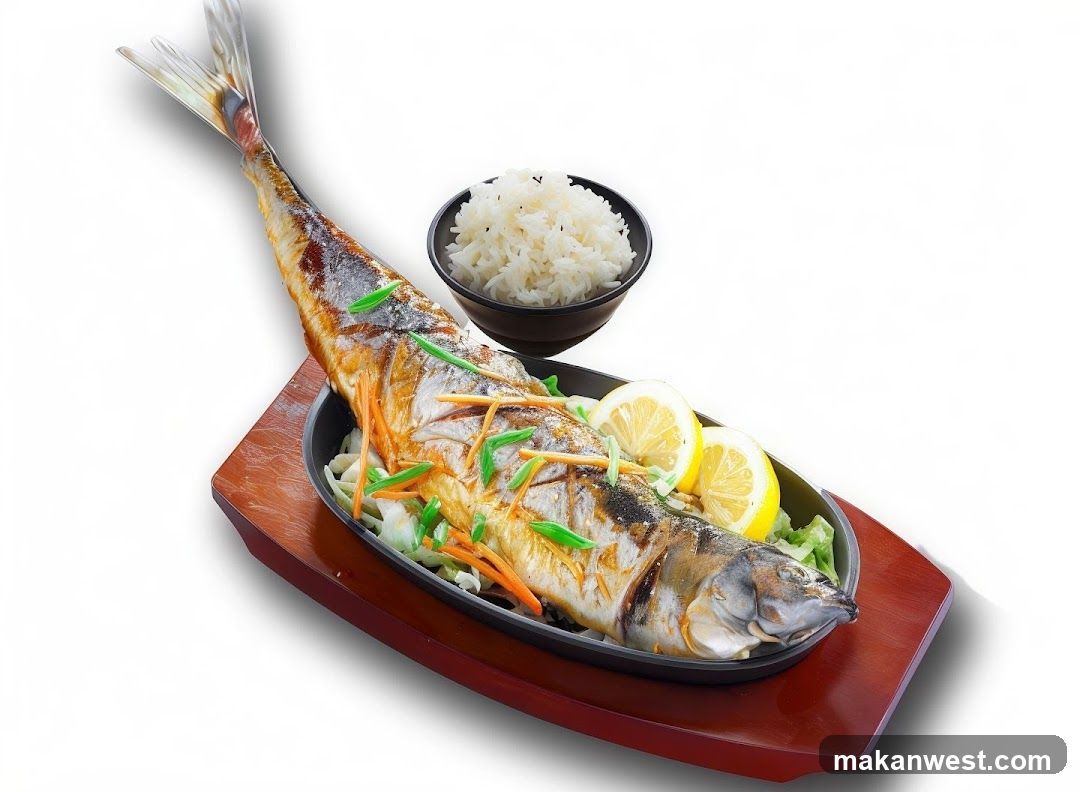 A whole grilled fish served on a bed of shredded cabbage and carrots, garnished with lemon slices and green onions. A bowl of white rice is placed behind the fish. The dish is presented on a wooden platter.